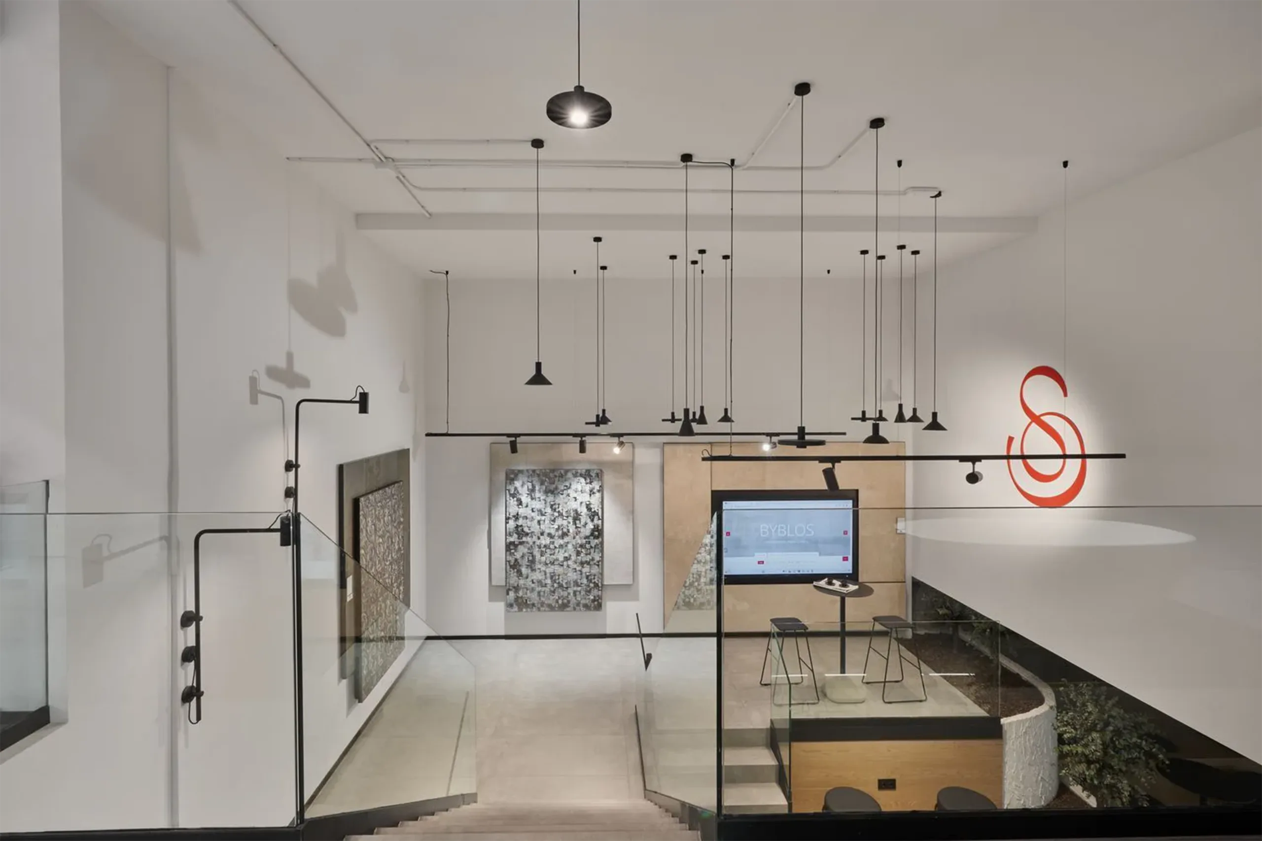 Vista de la planta superior del showroom SALONI Madrid con instalación de luminarias suspendidas, logotipo y zona de exposición