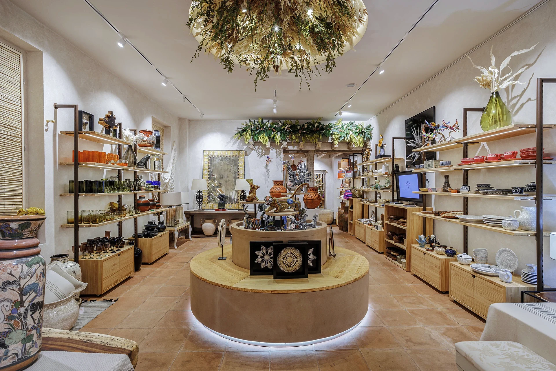 Espacio La Fuente en Huakal Madrid con expositor circular de barro cocido, instalación vegetal en techo y artesanía mexicana, diseñado por huuun