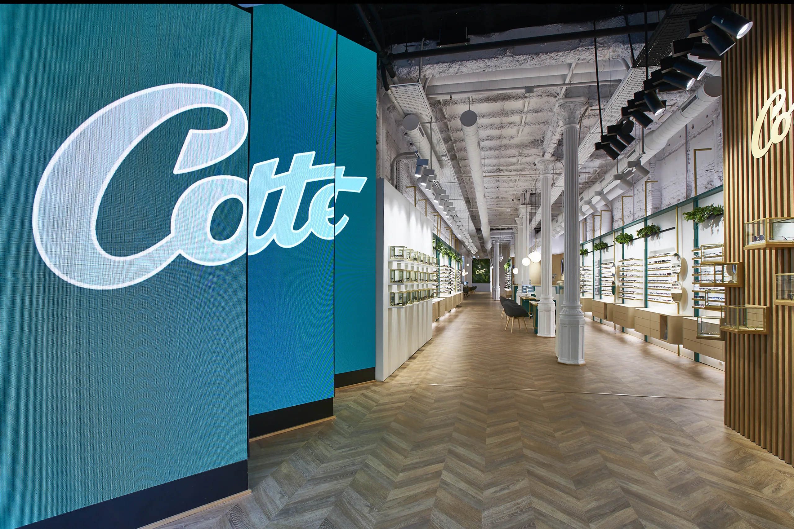 Acceso al flagship Cottet en Barcelona con pantalla LED azul y pasillo longitudinal de exposición