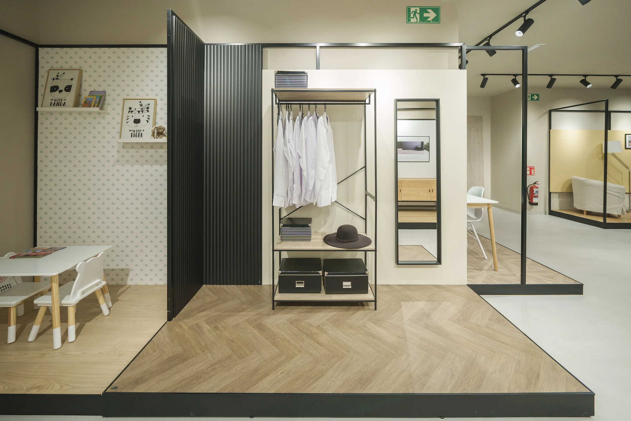 Ambientes escenográficos en la tienda FAUS de Madrid con tarimas de suelo laminado en espiga, zona infantil y vestidor