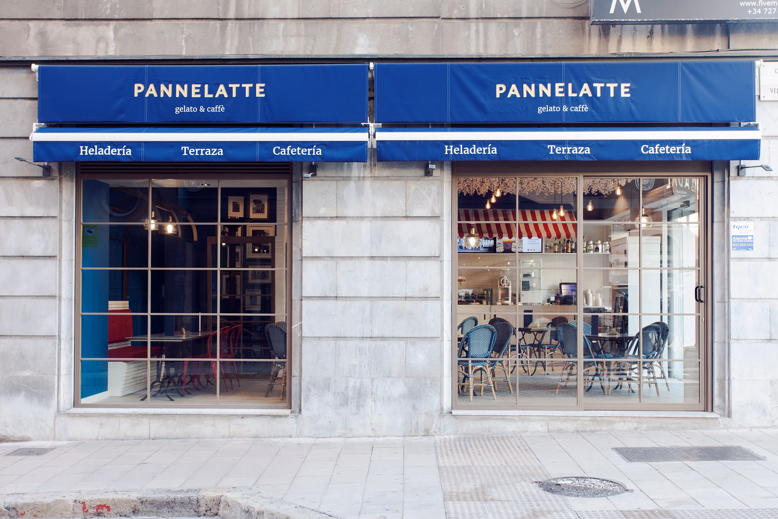 Fachada exterior de Pannelatte con toldos azules y rotulación dorada gelato & caffè