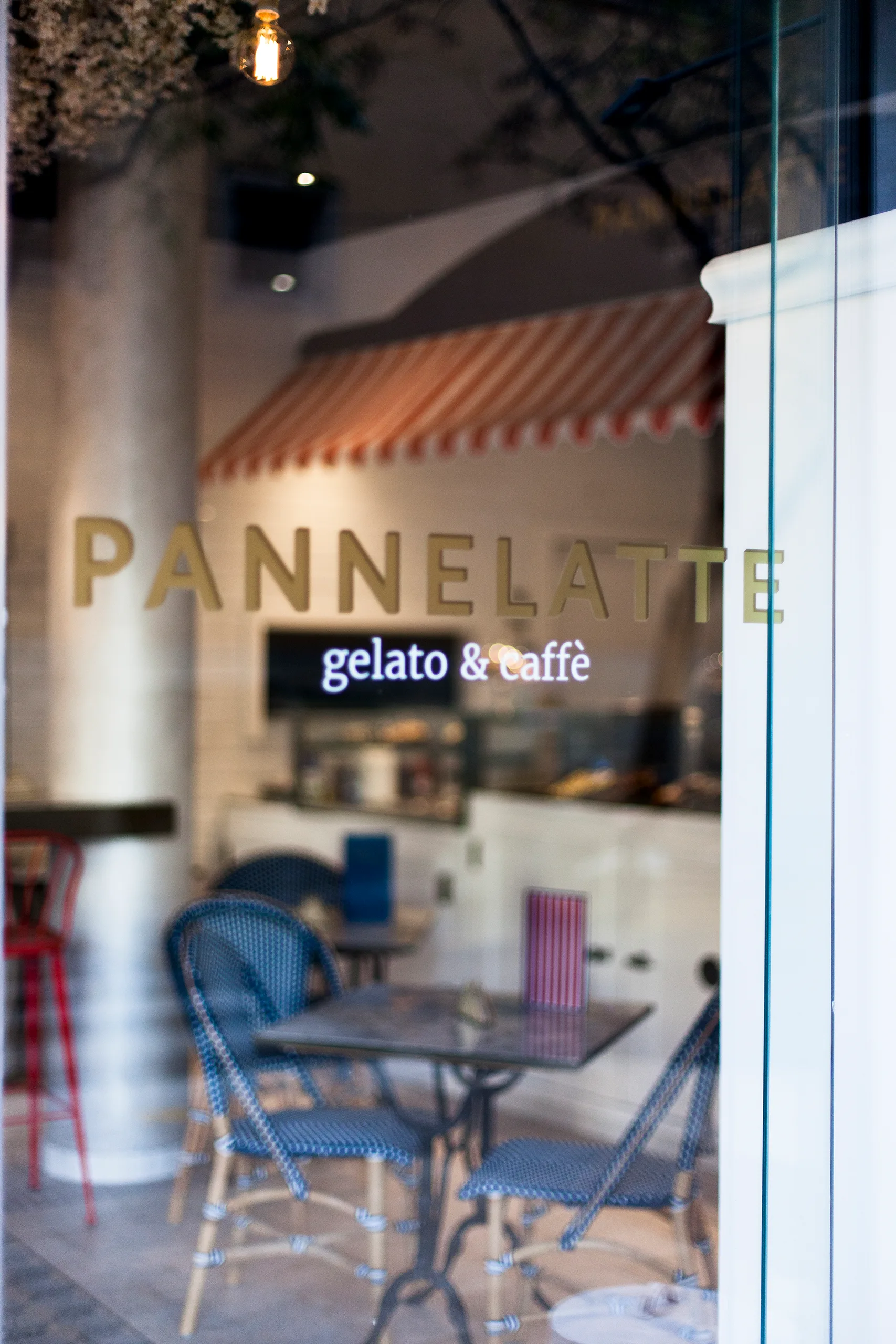 Rótulo dorado de Pannelatte en el cristal de la puerta con el interior al fondo